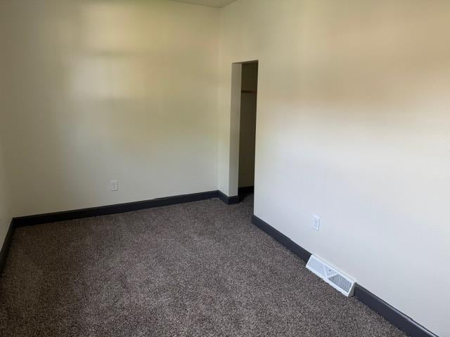 616 10th St, Minot, ND 58703 - empty room with dark carpet and baseboards