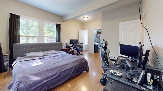 917 4th Ave, Minot, ND 58703 - bedroom with beamed ceiling, a desk, wood finished floors, and a walk in closet