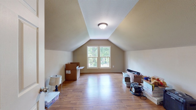 917 4th Ave, Minot, ND 58703 - bonus room featuring wood finished floors, lofted ceiling, and a textured ceiling