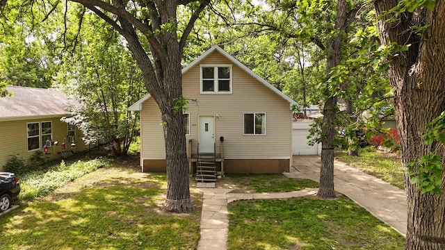 917 4th Ave, Minot, ND 58703 - view of front facade featuring entry steps, an outbuilding, a garage, and a front lawn