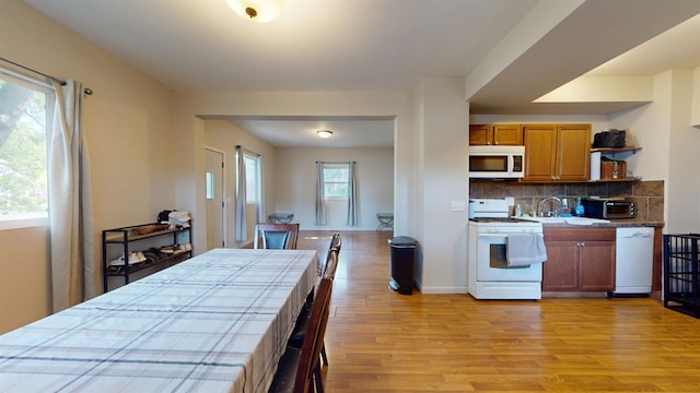 917 4th Ave, Minot, ND 58703 - kitchen with white appliances, light wood-style floors, a sink, open shelves, and tasteful backsplash