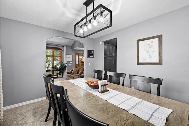 3304 12th St, Minot, ND 58701 - carpeted dining room featuring arched walkways and baseboards