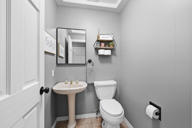 3304 12th St, Minot, ND 58701 - half bath featuring toilet, baseboards, tile patterned floors, and a sink