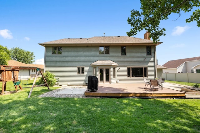 3304 12th St, Minot, ND 58701 - back of property featuring a chimney, a playground, and a deck