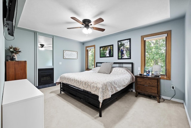 3304 12th St, Minot, ND 58701 - bedroom with light colored carpet, multiple windows, baseboards, and a fireplace