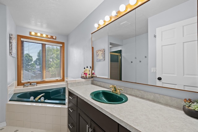 3304 12th St, Minot, ND 58701 - full bathroom featuring vanity, a bath, and a stall shower