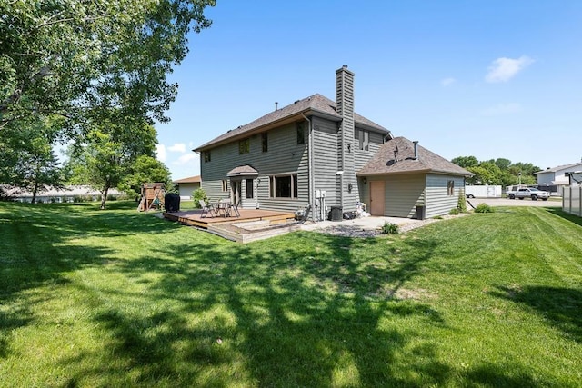 3304 12th St, Minot, ND 58701 - back of property featuring a chimney, a playground, and a wooden deck