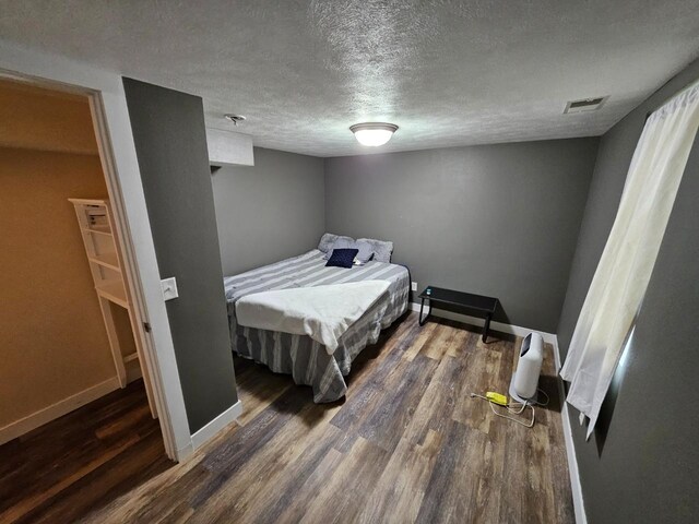 320 7th St, Minot, ND 58703 - bedroom with a textured ceiling, wood finished floors, and baseboards
