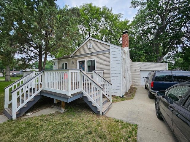 320 7th St, Minot, ND 58703 - view of front of home with a chimney, a garage, driveway, and a deck