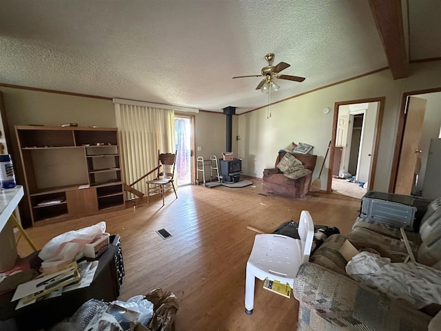 3622 4th Ave, Balfour, ND 58712 - living room with a wood stove, ceiling fan, wood finished floors, a textured ceiling, and crown molding