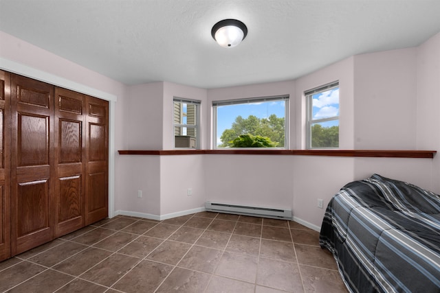 1705 SW Evergreen Ave, Minot, ND 58701 - unfurnished bedroom with a baseboard radiator and dark tile patterned floors