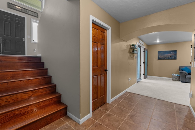 1705 SW Evergreen Ave, Minot, ND 58701 - staircase featuring arched walkways, carpet, and tile patterned floors