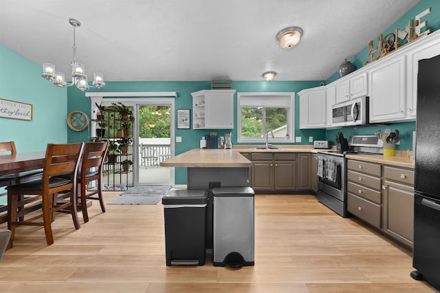 1705 SW Evergreen Ave, Minot, ND 58701 - kitchen with appliances with stainless steel finishes, gray cabinets, light wood-style floors, light countertops, and a chandelier