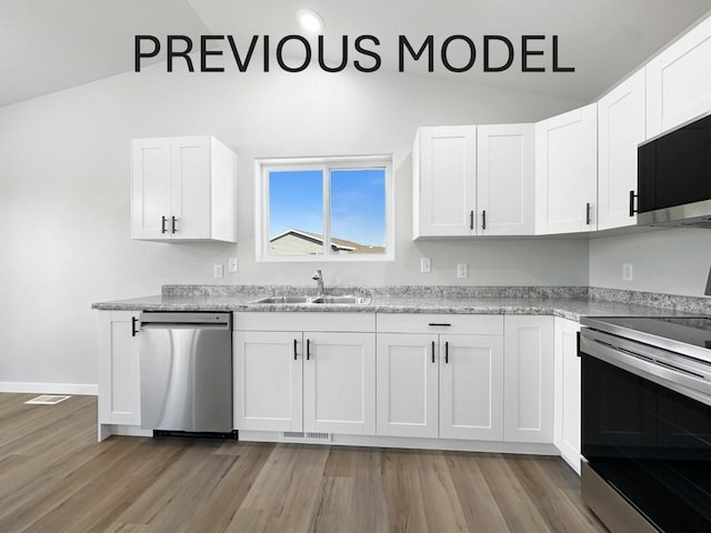 324 7th Ave, Surrey, ND 58785 - kitchen with appliances with stainless steel finishes, light wood-type flooring, white cabinets, light countertops, and high vaulted ceiling