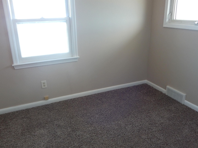 2014 4th St, Minot, ND 58703 - spare room featuring carpet floors and plenty of natural light