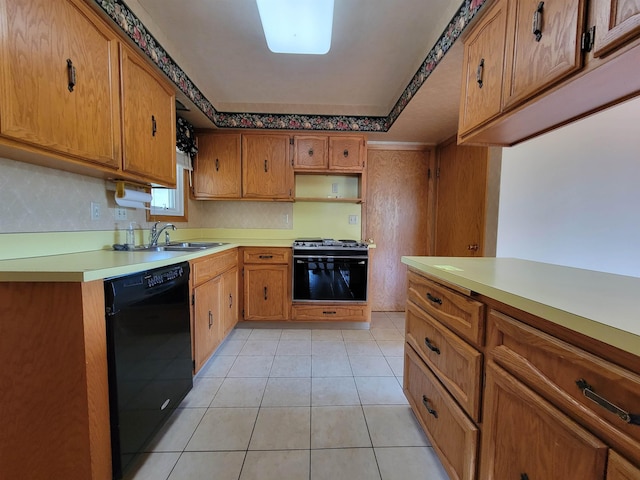 1000 21st St, Minot, ND 58703 - kitchen featuring black dishwasher, gas range oven, light countertops, brown cabinets, and light tile patterned floors