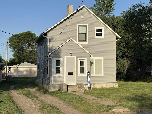 510 4th St, Minot, ND 58703 - view of front of home featuring a chimney, a front yard, and entry steps