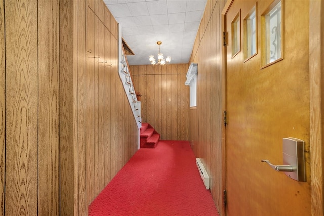 306 2nd St, Towner, ND 58788 - hallway featuring a baseboard heating unit, a chandelier, stairway, carpet, and wooden walls