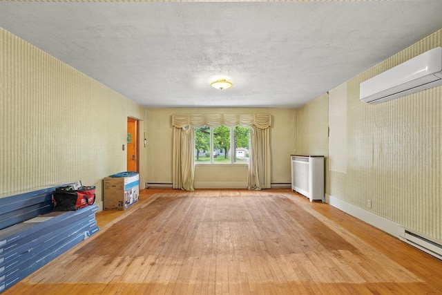 306 2nd St, Towner, ND 58788 - unfurnished living room with an AC wall unit, wood-type flooring, and a baseboard radiator