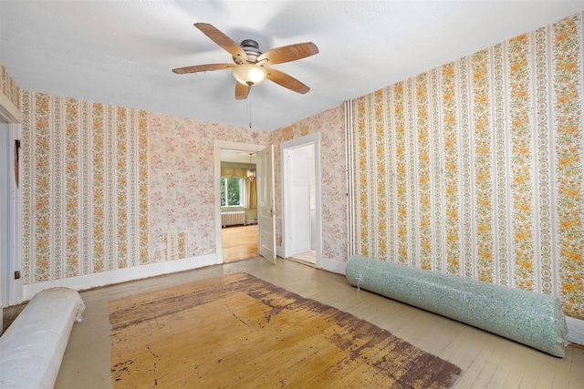 306 2nd St, Towner, ND 58788 - unfurnished room with wood-type flooring, radiator, and a ceiling fan