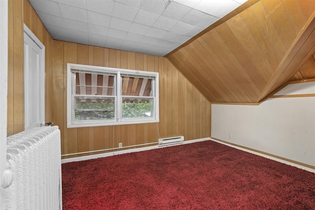 306 2nd St, Towner, ND 58788 - additional living space featuring a baseboard heating unit, radiator, wooden walls, vaulted ceiling, and carpet