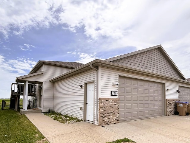 3119 8th St, Minot, ND 58703 - view of property exterior with brick siding, driveway, and an attached garage