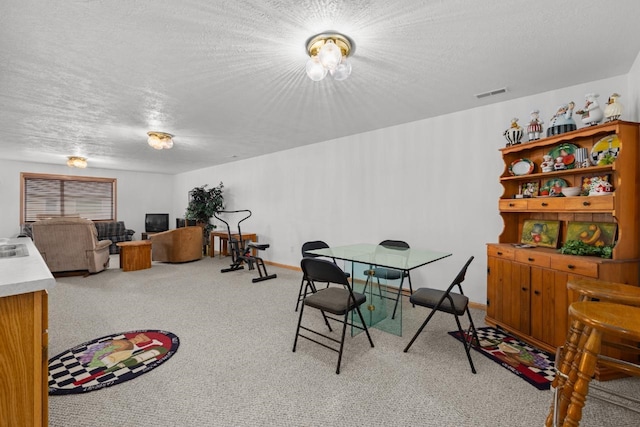 2009 14th St, Minot, ND 58703 - dining space featuring light carpet and a textured ceiling