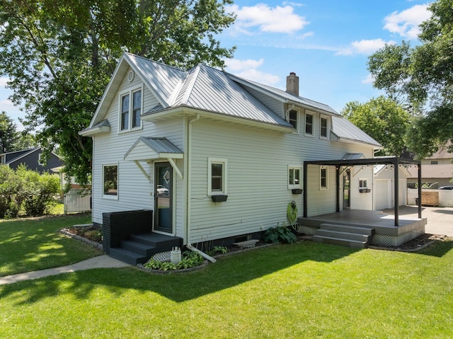 211 W 3rd St, Velva, ND 58790 - rear view of property with a metal roof, a chimney, a lawn, and a standing seam roof