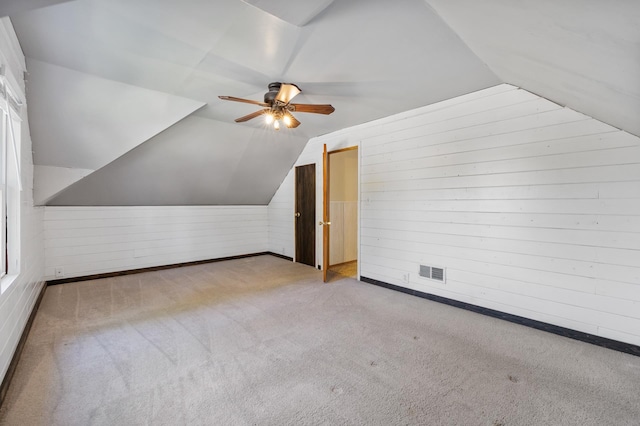 211 W 3rd St, Velva, ND 58790 - additional living space with wood walls, ceiling fan, lofted ceiling, and carpet
