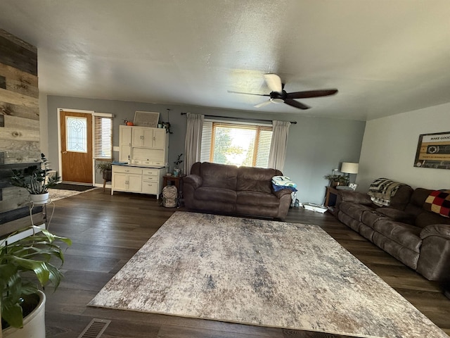 3301 SE 1st St, Minot, ND 58701 - living room with a ceiling fan, a fireplace, and dark wood-type flooring