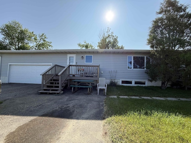 3301 SE 1st St, Minot, ND 58701 - view of front of property with asphalt driveway, a deck, and an attached garage