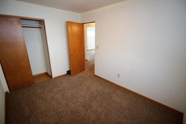 1809 Main St, Minot, ND 58701 - unfurnished bedroom featuring carpet and a closet