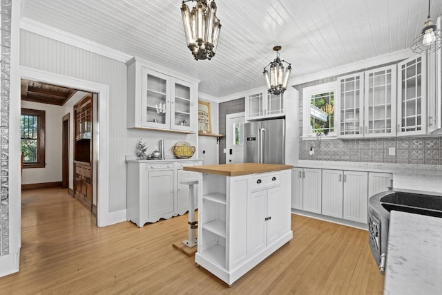 519 4th St, Minot, ND 58701 - kitchen with high quality fridge, open shelves, butcher block countertops, a chandelier, and ornamental molding