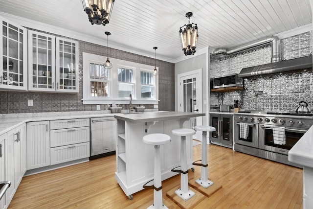 519 4th St, Minot, ND 58701 - kitchen featuring stainless steel appliances, wine cooler, light wood finished floors, glass insert cabinets, and decorative backsplash