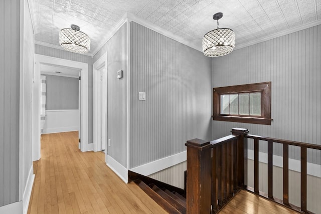 519 4th St, Minot, ND 58701 - hallway featuring an ornate ceiling, a chandelier, ornamental molding, hardwood / wood-style flooring, and an upstairs landing