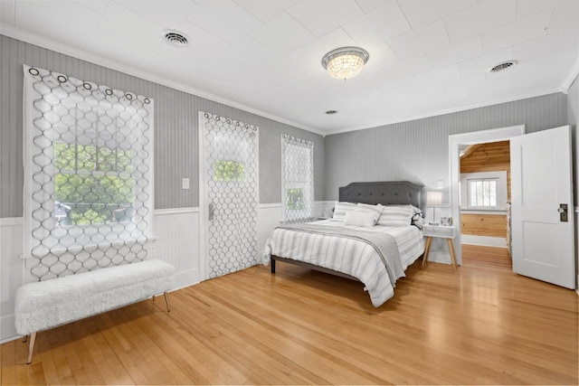 519 4th St, Minot, ND 58701 - bedroom with crown molding and light wood-style floors