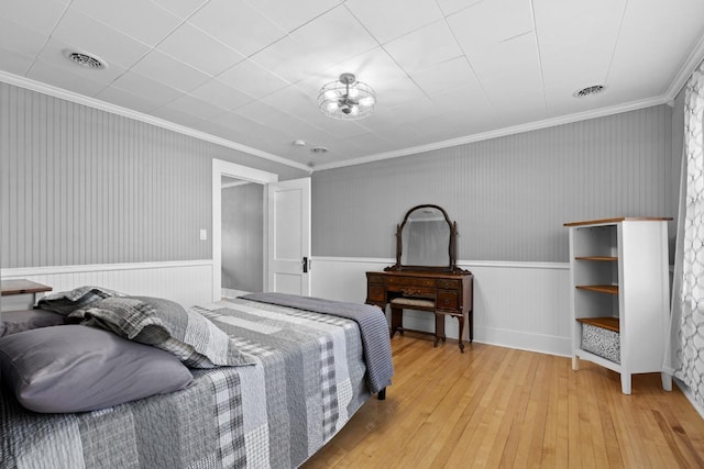 519 4th St, Minot, ND 58701 - bedroom featuring light wood-style floors, a wainscoted wall, and crown molding