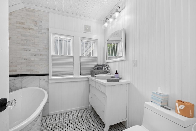 519 4th St, Minot, ND 58701 - bathroom featuring ornamental molding, vanity, a soaking tub, tile patterned floors, and wooden walls