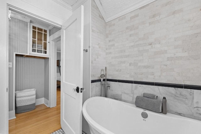 519 4th St, Minot, ND 58701 - bathroom with a soaking tub, crown molding, and wood finished floors