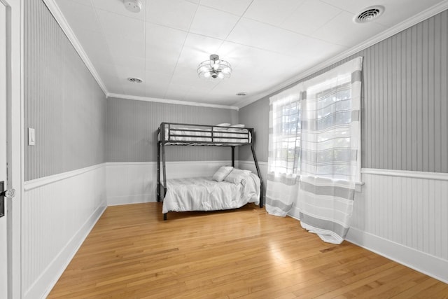 519 4th St, Minot, ND 58701 - bedroom featuring hardwood / wood-style flooring, crown molding, and wainscoting