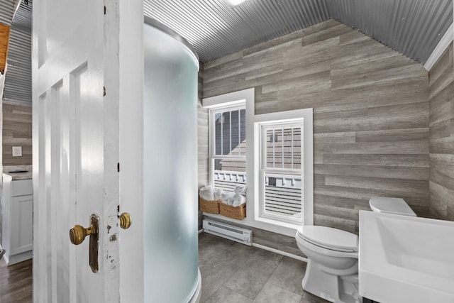 519 4th St, Minot, ND 58701 - bathroom with a baseboard heating unit, wooden walls, and tile patterned floors