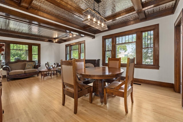 519 4th St, Minot, ND 58701 - dining area with light wood-type flooring, beam ceiling, and a chandelier