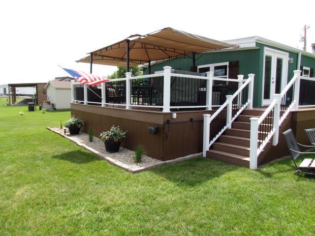 83 Hahns Bay Rd, Lake Metigoshe, ND 58318 - rear view of house with a deck and a lawn