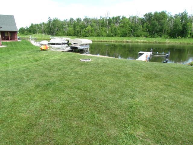 83 Hahns Bay Rd, Lake Metigoshe, ND 58318 - view of grassy yard with a water view
