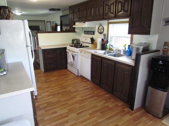 83 Hahns Bay Rd, Lake Metigoshe, ND 58318 - kitchen featuring white appliances, light wood-style floors, and dark brown cabinetry