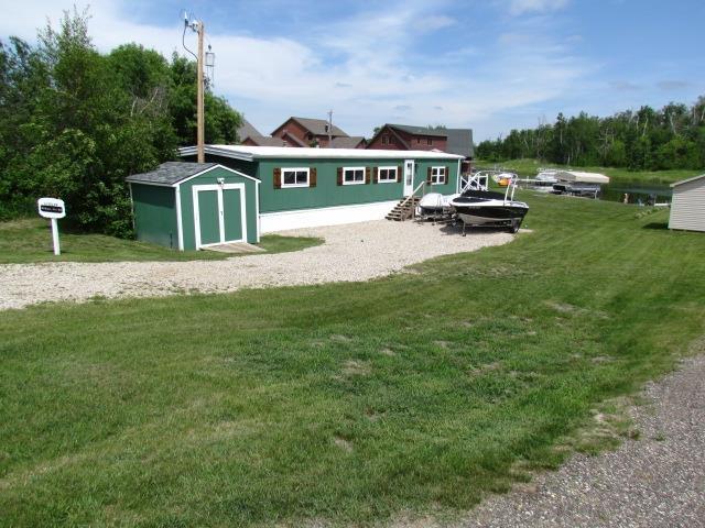 83 Hahns Bay Rd, Lake Metigoshe, ND 58318 - back of property with a storage shed and a lawn