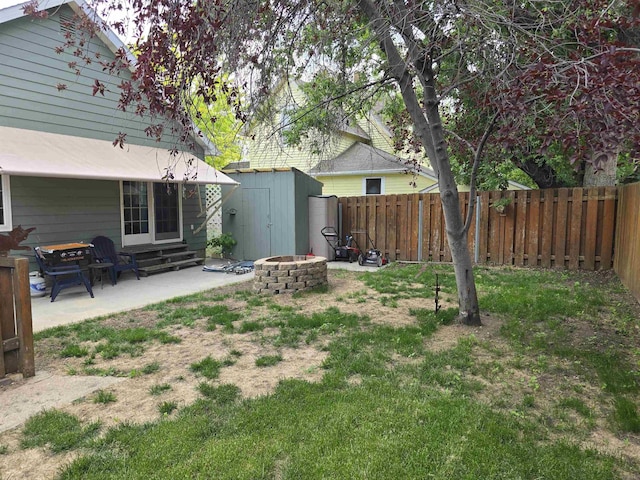 209 University Ave, Minot, ND 58703 - fenced backyard featuring a fire pit, a patio area, a shed, and entry steps