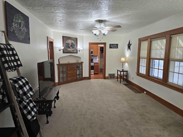 209 University Ave, Minot, ND 58703 - sitting room featuring carpet, a textured ceiling, and ceiling fan