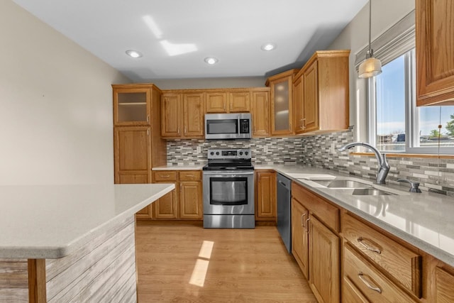 1949 24th St, Minot, ND 58701 - kitchen with appliances with stainless steel finishes, light countertops, hanging light fixtures, backsplash, and recessed lighting