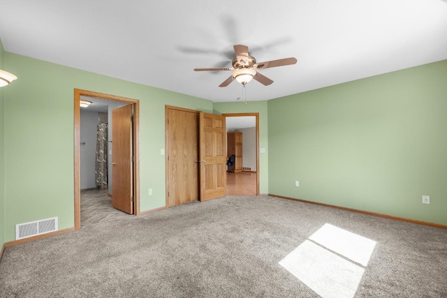 1949 24th St, Minot, ND 58701 - unfurnished bedroom featuring light colored carpet, a ceiling fan, and a closet